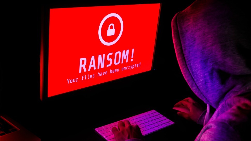 Ransomware on computer with hacker.jpg