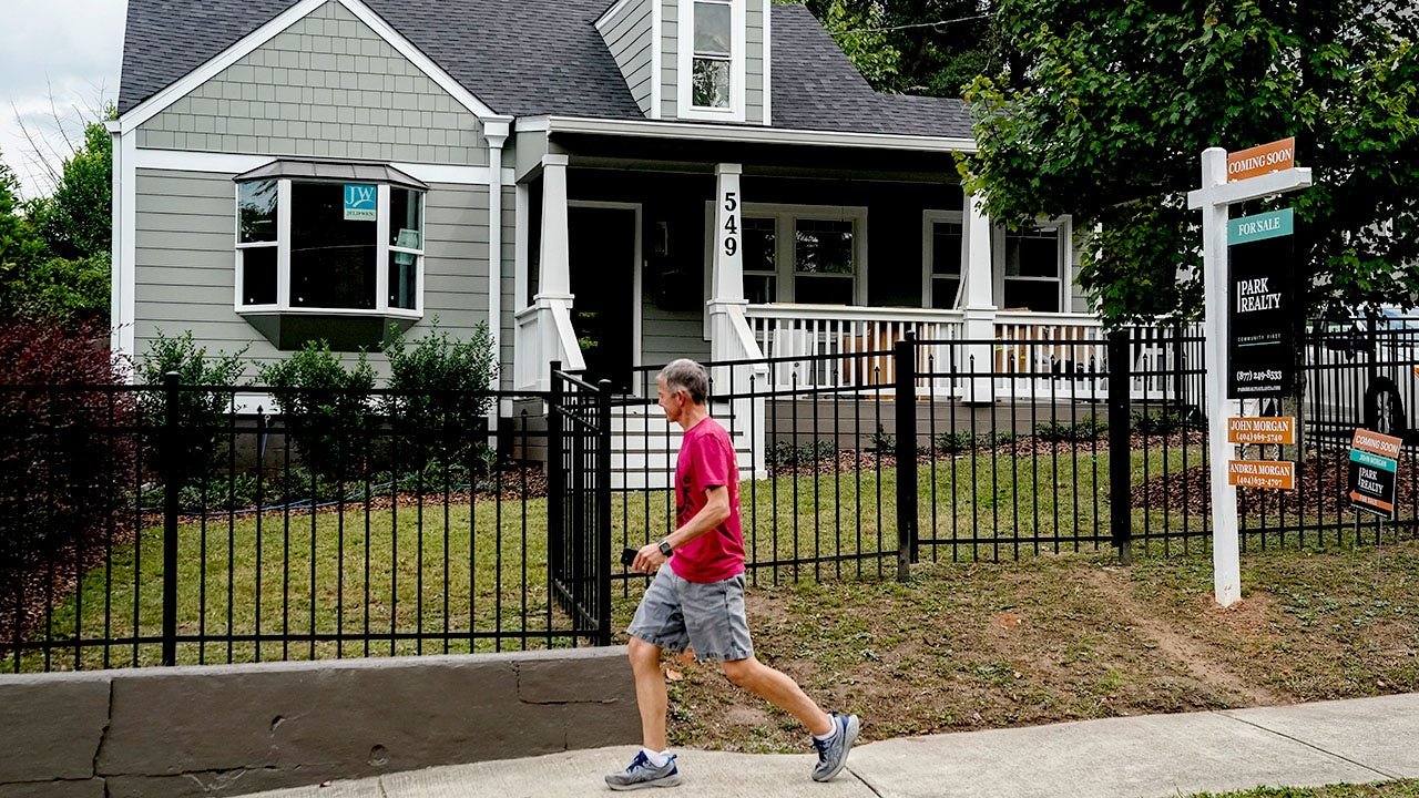 Real estate sign man walking.jpg