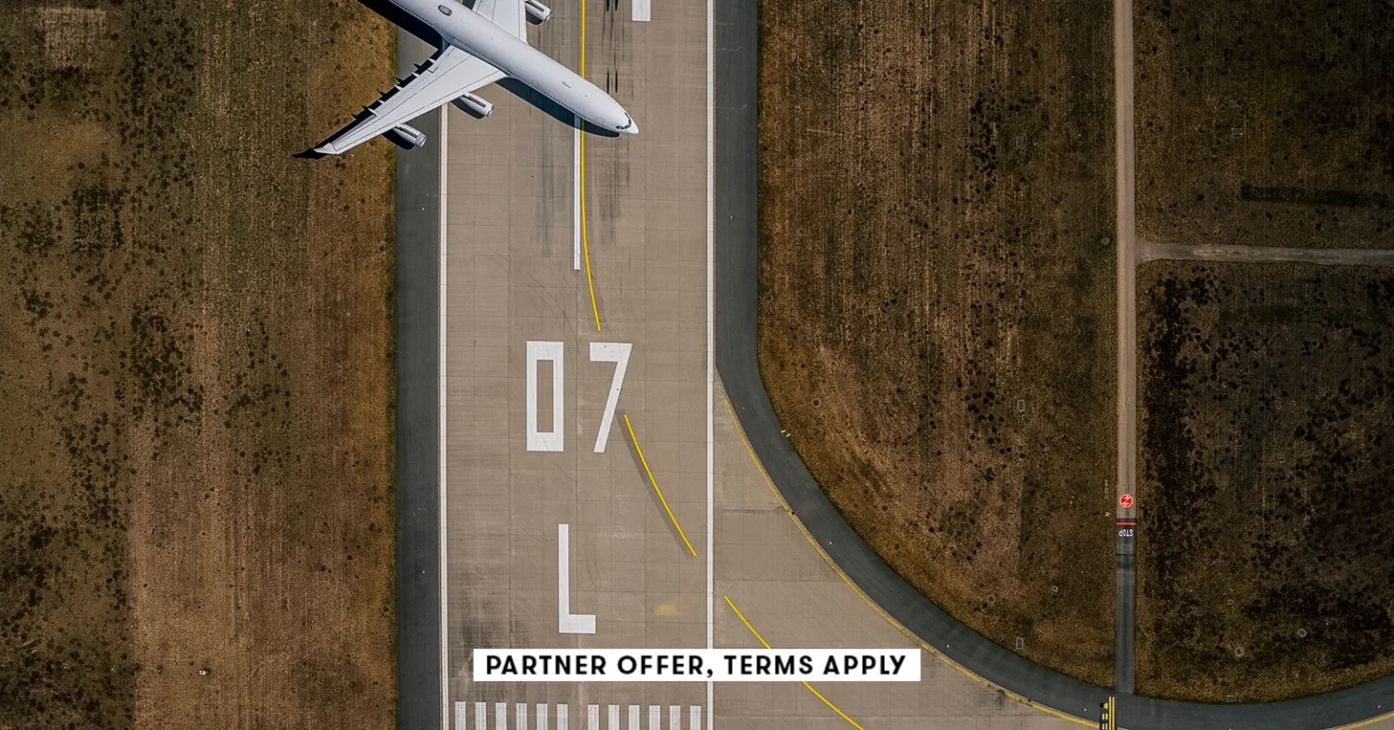 20250715 SOCIAL DISCLAIMER PARTER OFFER TERMS APPLY Birds eye view of airplane parked on airport run.webp