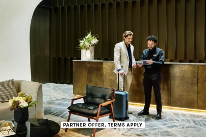 20250715 SOCIAL DISCLAIMER PARTER OFFER TERMS APPLY HOTEL MANAGER CHECKING IN BUSINESSMAN INTO HOTEL.webp