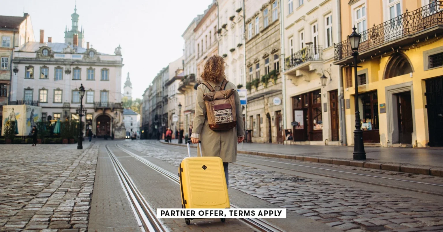 SOCIAL IMAGE PARTNER OFFER TERMS APPLY woman with a suitcase walking on European street Nazar Rybak.webp