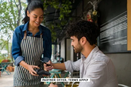 SOCIAL IMAGE PARTNER OFFER TERMS APPLY Man making a contacless payment at a restaurant using his cel.webp