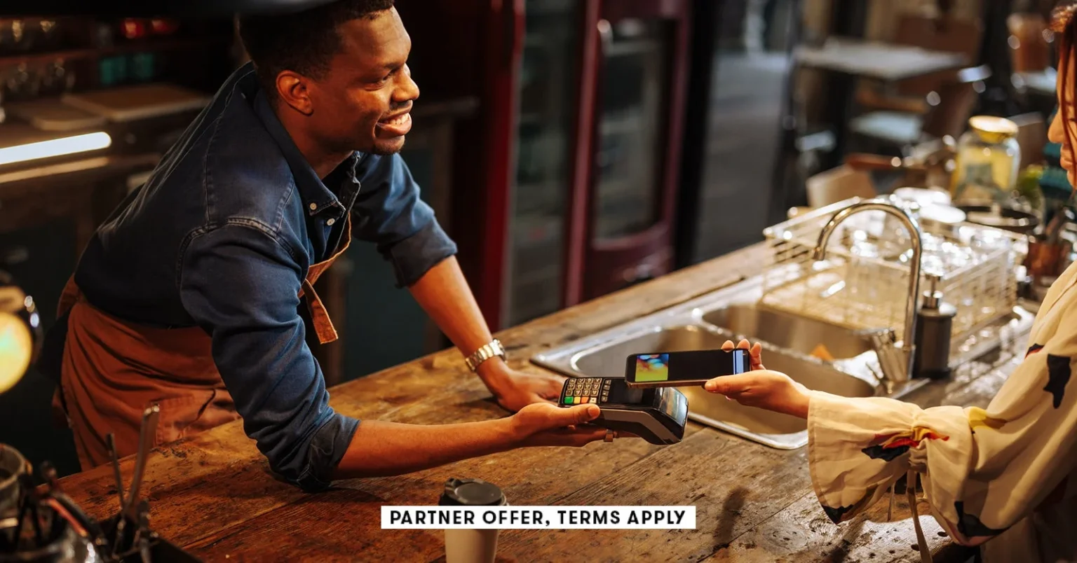 SOCIAL IMAGE PARTNER OFFERS TERMS APPLY Bartender holding contactless payment terminal for person to.webp