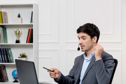 Customer service cute guy grey suit with computer headset holding fists up.jpg