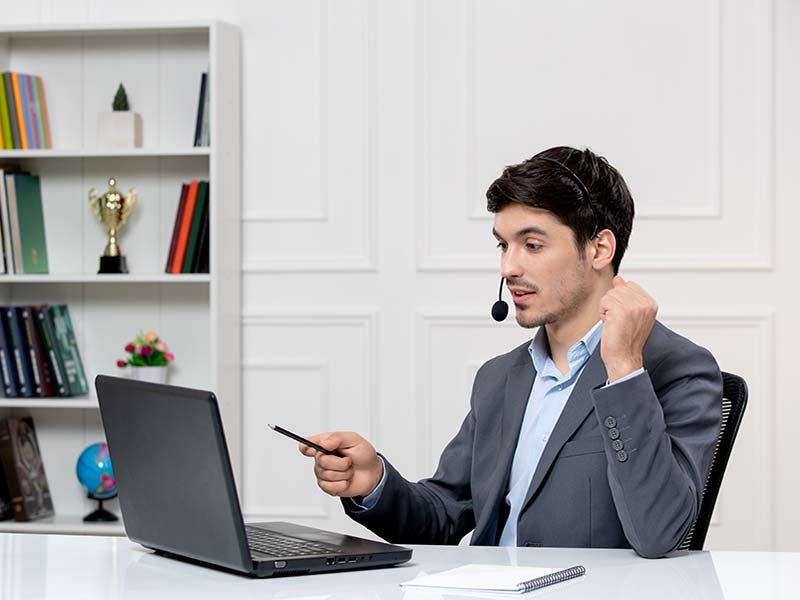 Customer service cute guy grey suit with computer headset holding fists up.jpg