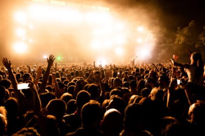 Rear view large group music fans front stage music concert by night copy space 1024x576.jpg