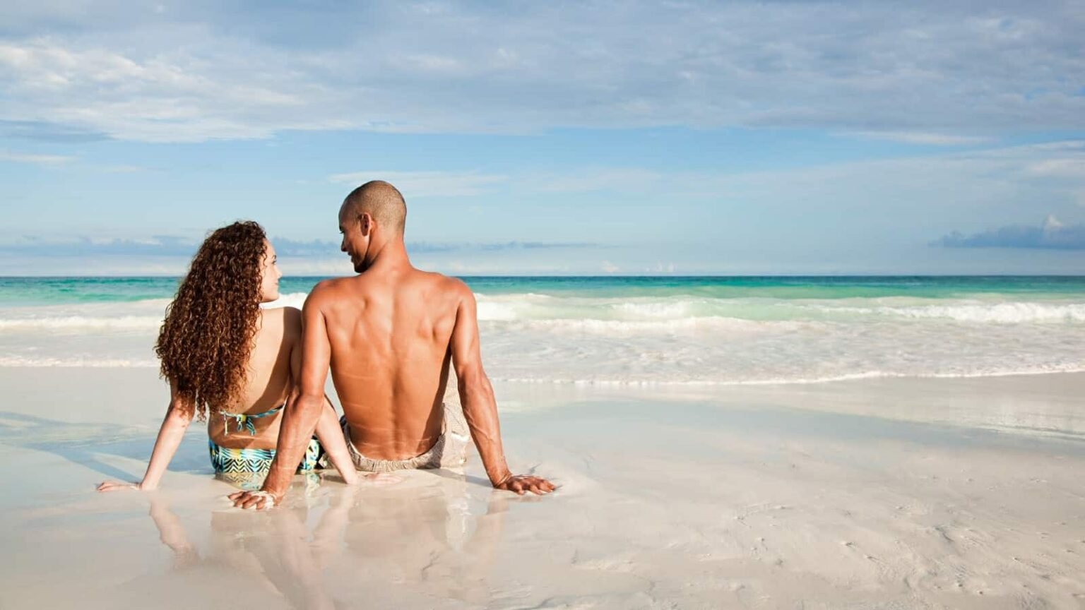 Young couple beach ocean travel vacation fun luxury.jpg